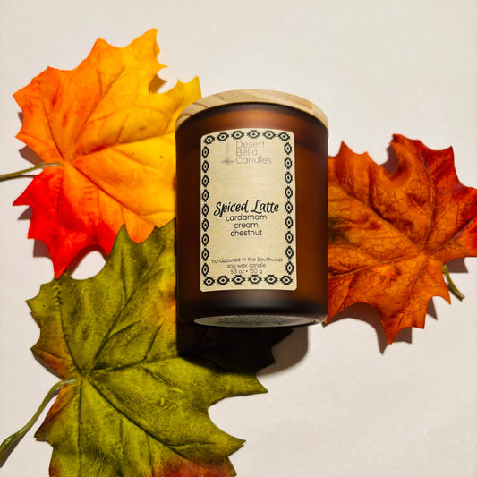 Spiced Latte candle with autumn leaves on a light background